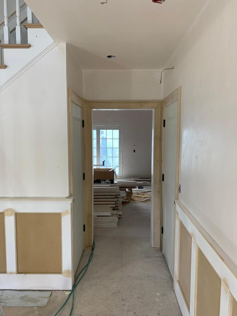 Hallway with door casings and wainscoting by WHB Construction Corp.