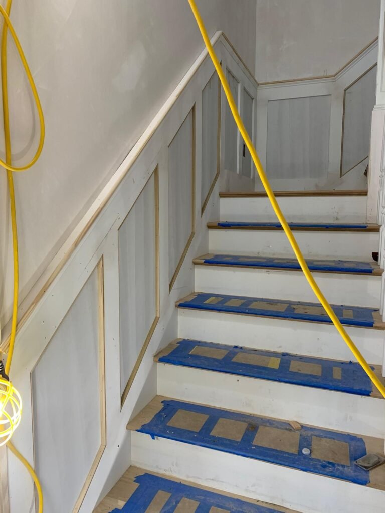 Staircase with wainscoting by WHB Construction Corp.